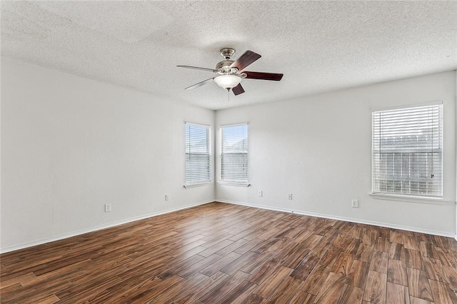 empty room featuring ceiling fan, dark hardwood / wood-style flooring, and a healthy amount of sunlight