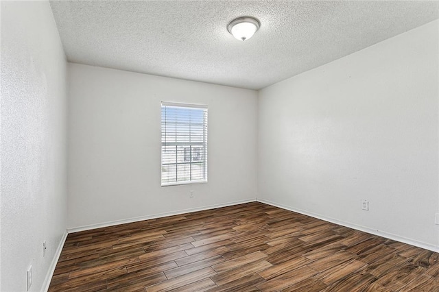 spare room with dark hardwood / wood-style floors and a textured ceiling