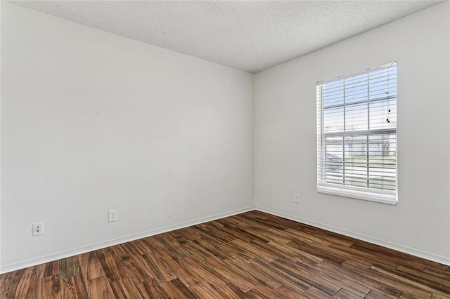 unfurnished room with a textured ceiling and dark hardwood / wood-style floors