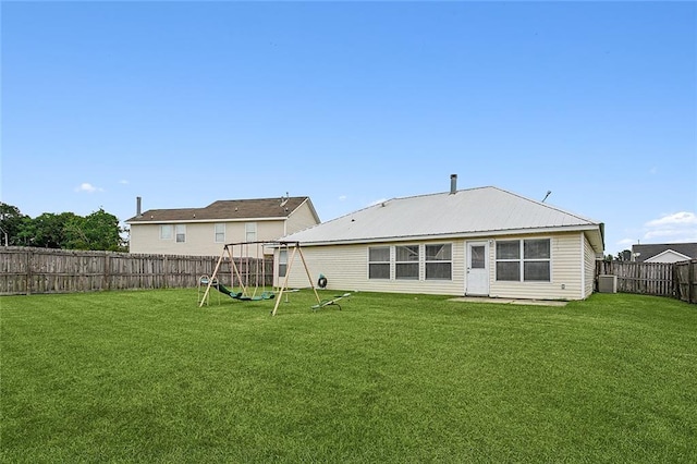 back of property with a yard and a playground