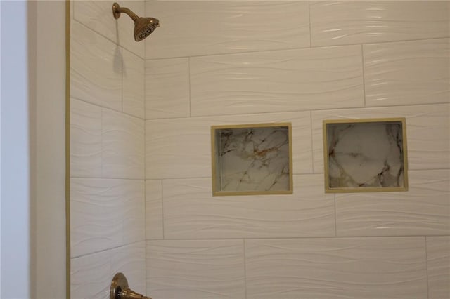 interior details featuring a tile shower