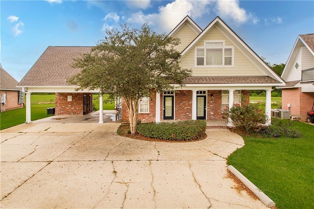 view of front of house with cooling unit, a front lawn, and a carport