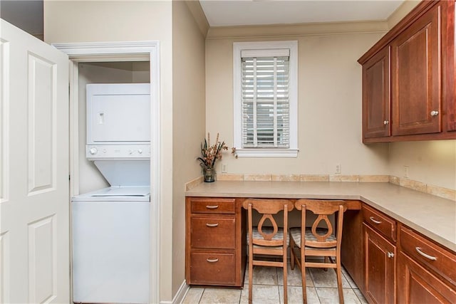 interior space featuring light tile patterned flooring and stacked washer and dryer