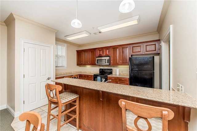 kitchen featuring pendant lighting, a kitchen bar, black appliances, light tile patterned floors, and crown molding