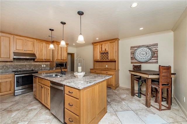 kitchen featuring decorative light fixtures, light stone countertops, appliances with stainless steel finishes, a kitchen island with sink, and sink