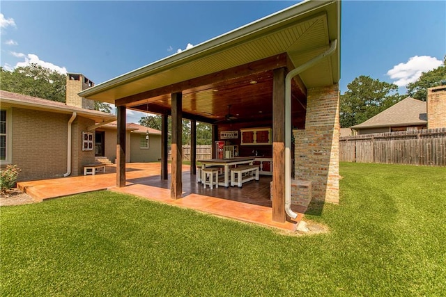 view of yard with ceiling fan and a patio