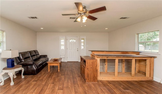 living room featuring dark wood-type flooring and ceiling fan