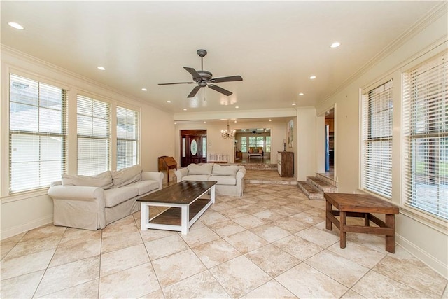 living room with plenty of natural light, ceiling fan with notable chandelier, baseboards, and ornamental molding