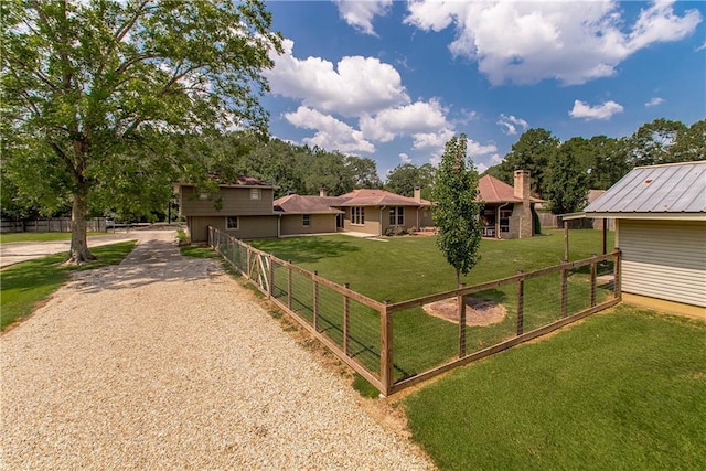 view of yard with gravel driveway and fence