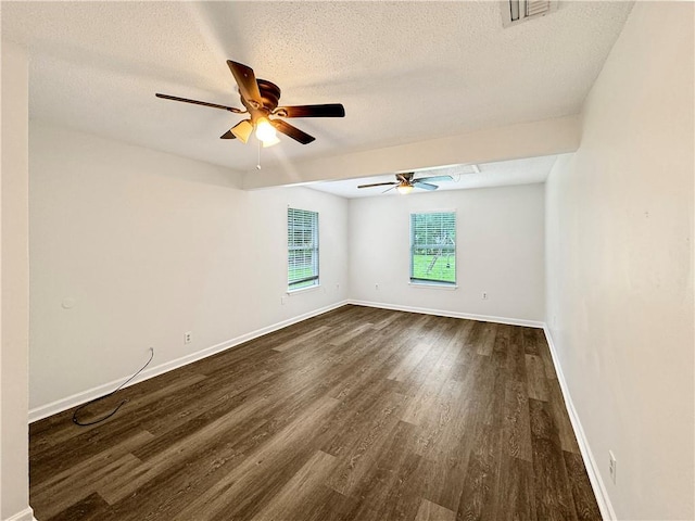 empty room featuring dark wood-type flooring, ceiling fan, and a textured ceiling