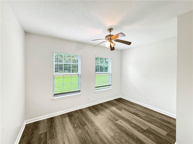 empty room with a textured ceiling, ceiling fan, and dark hardwood / wood-style floors