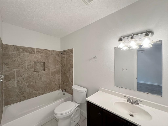 full bathroom featuring tile patterned flooring, toilet, tiled shower / bath combo, vanity, and a textured ceiling