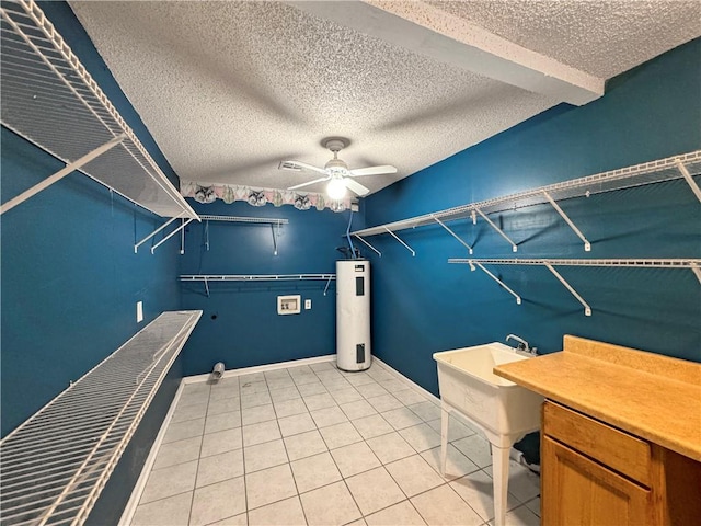 interior space with a textured ceiling, ceiling fan, electric water heater, and light tile patterned flooring