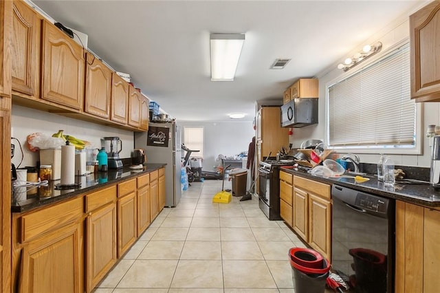 kitchen with dark stone countertops, black appliances, sink, and light tile patterned flooring