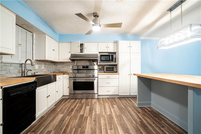 kitchen featuring pendant lighting, butcher block counters, white cabinets, decorative backsplash, and stainless steel appliances