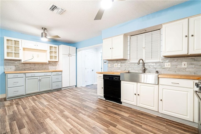 kitchen with white cabinetry, black dishwasher, a textured ceiling, and wood counters