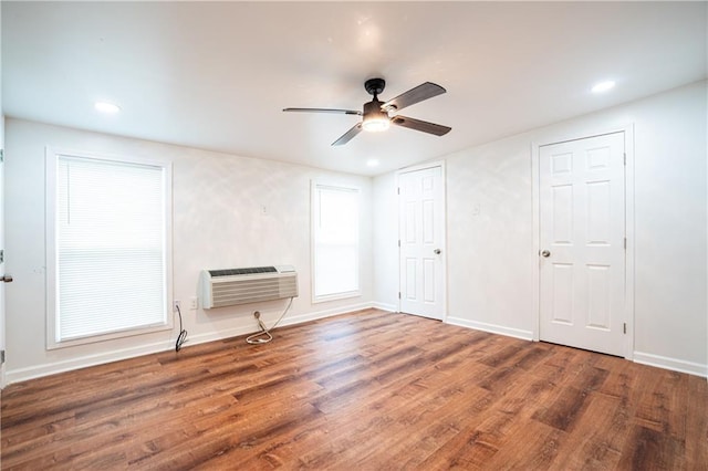 unfurnished room featuring dark wood-type flooring, ceiling fan, and a wall mounted AC