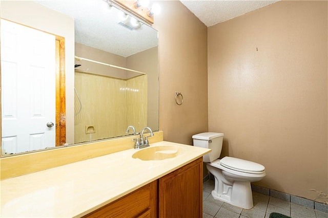 bathroom featuring toilet, a shower, a textured ceiling, vanity, and tile patterned flooring