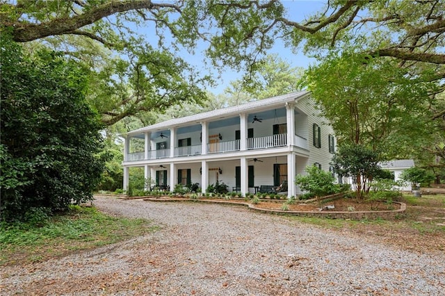 greek revival inspired property featuring a balcony, ceiling fan, and covered porch