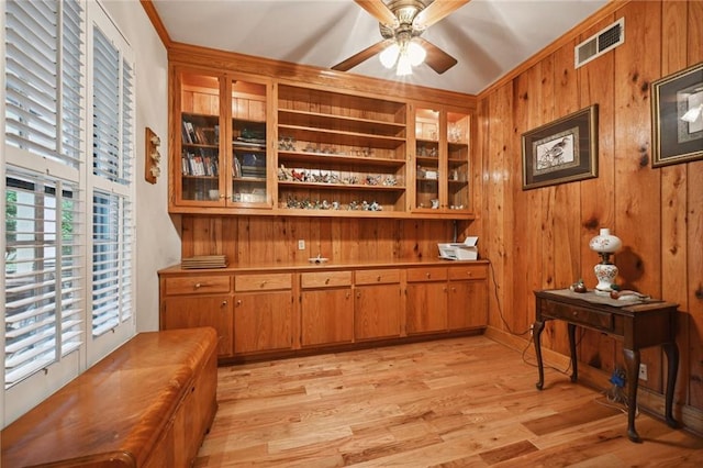 office with crown molding, ceiling fan, wood walls, and light hardwood / wood-style floors