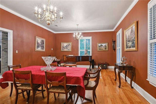 dining area with crown molding, an inviting chandelier, and light wood-type flooring