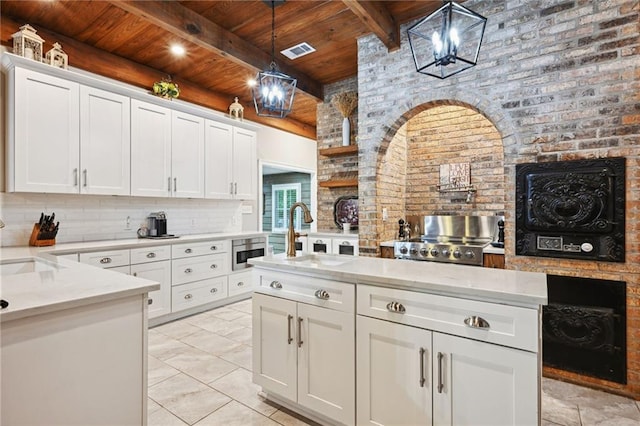 kitchen with wood ceiling, pendant lighting, sink, and white cabinets