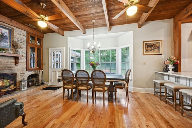 dining room featuring ceiling fan with notable chandelier, wood ceiling, and a fireplace