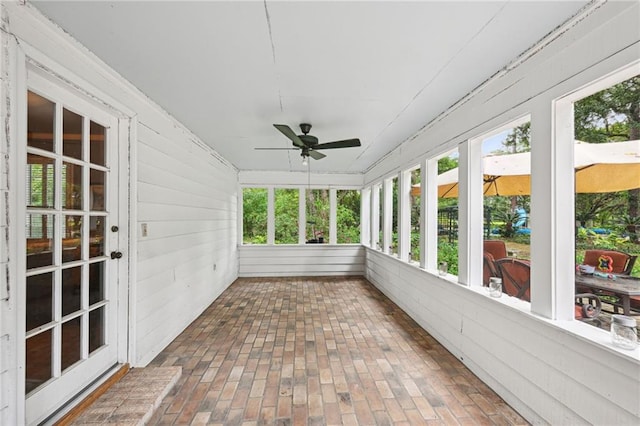 unfurnished sunroom with ceiling fan