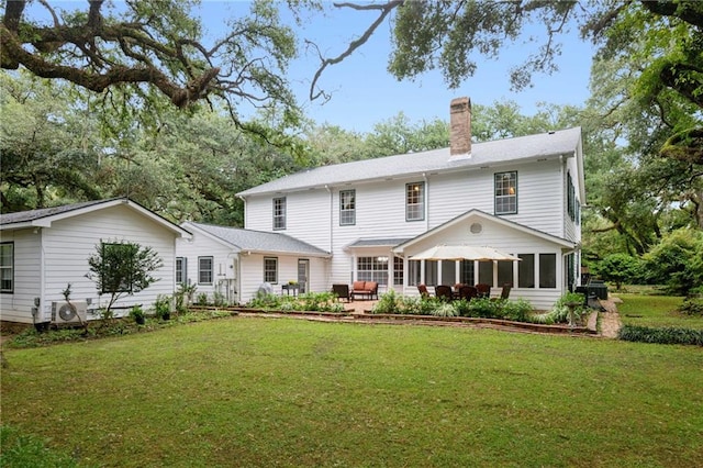 rear view of house with ac unit and a yard