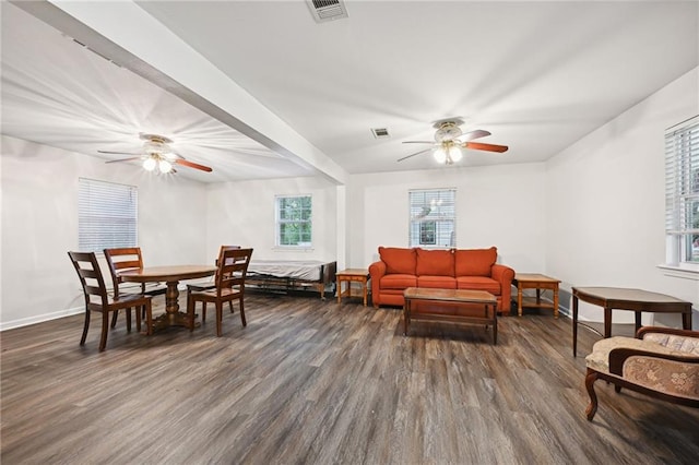 living room featuring dark wood-type flooring and ceiling fan