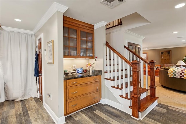 staircase featuring ornamental molding and hardwood / wood-style flooring