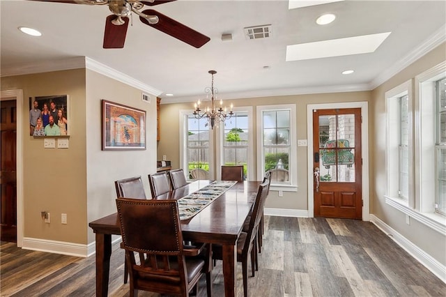 dining area with a skylight, ceiling fan with notable chandelier, dark hardwood / wood-style floors, and ornamental molding