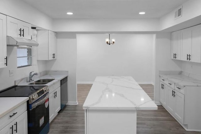 kitchen with white cabinets, a kitchen island, stainless steel appliances, and light stone countertops