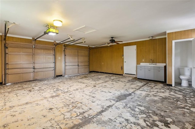 garage with ceiling fan, wood walls, and sink