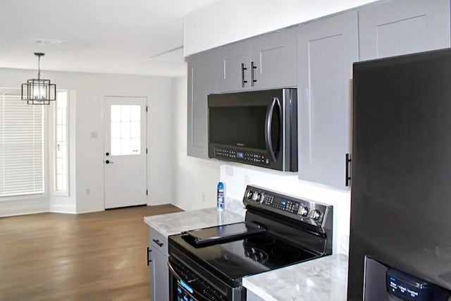 kitchen featuring a chandelier, decorative light fixtures, black appliances, dark hardwood / wood-style floors, and gray cabinetry