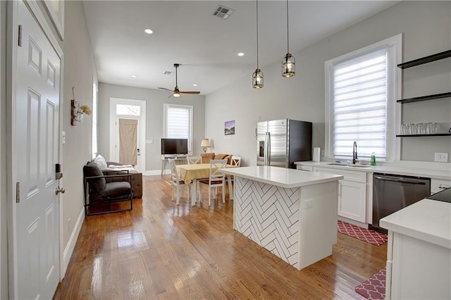 kitchen featuring plenty of natural light, stainless steel appliances, pendant lighting, and sink