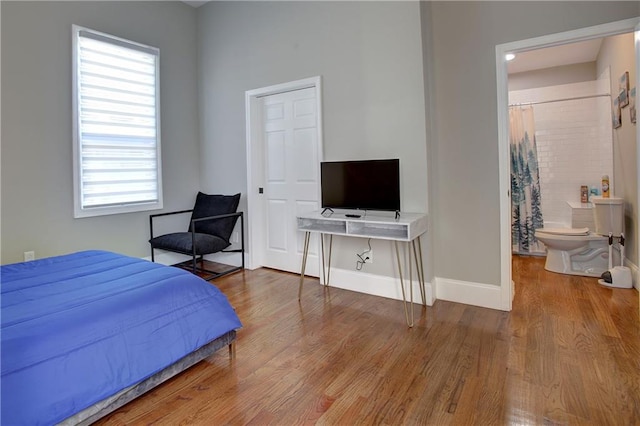 bedroom featuring ensuite bathroom and hardwood / wood-style flooring