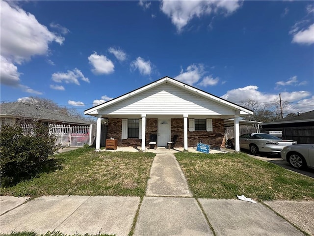 view of front of property featuring covered porch and a front lawn