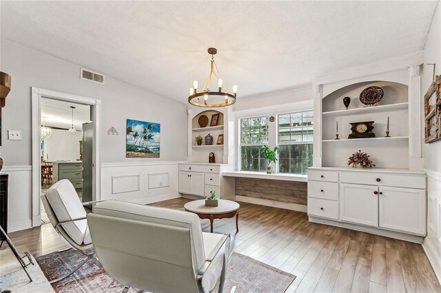 living room featuring crown molding, light hardwood / wood-style flooring, and vaulted ceiling