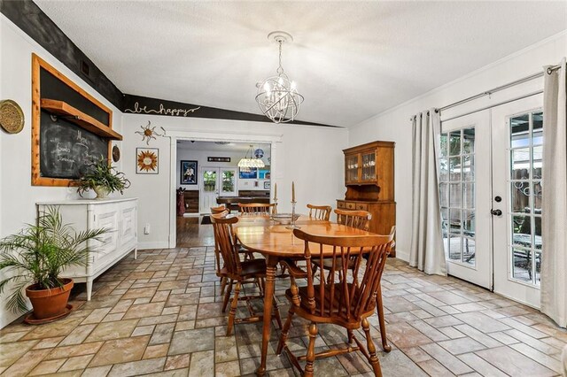 dining space with an inviting chandelier, plenty of natural light, and french doors