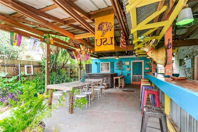 view of patio / terrace with exterior bar and a hot tub