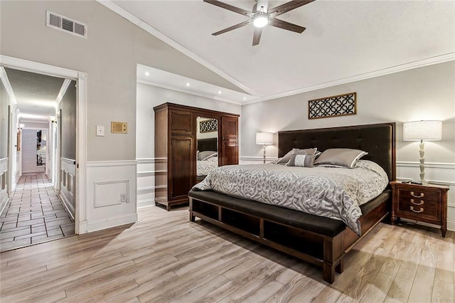 bedroom with ornamental molding, lofted ceiling, ceiling fan, and light wood-type flooring