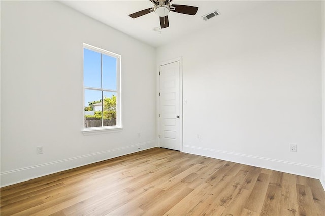 empty room with ceiling fan and light hardwood / wood-style floors