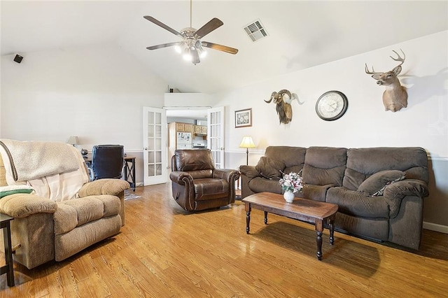 living room featuring light wood-type flooring, french doors, vaulted ceiling, and ceiling fan