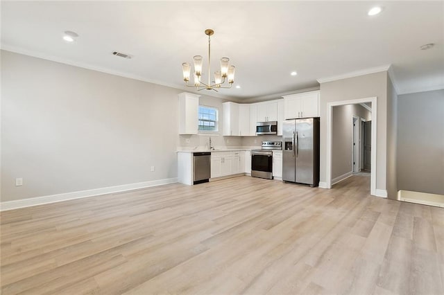 kitchen featuring light hardwood / wood-style flooring, white cabinets, appliances with stainless steel finishes, and decorative light fixtures