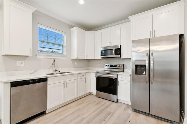 kitchen featuring light hardwood / wood-style flooring, stainless steel appliances, sink, and white cabinetry