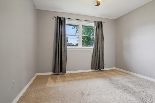 carpeted empty room featuring ceiling fan