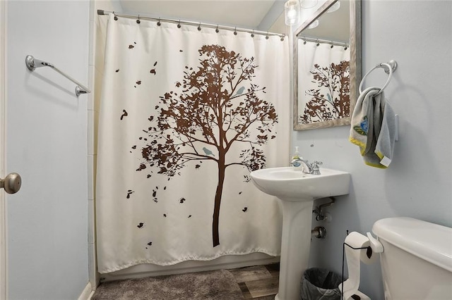 bathroom featuring curtained shower and toilet