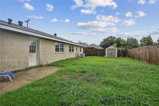 view of yard featuring a storage shed and central AC