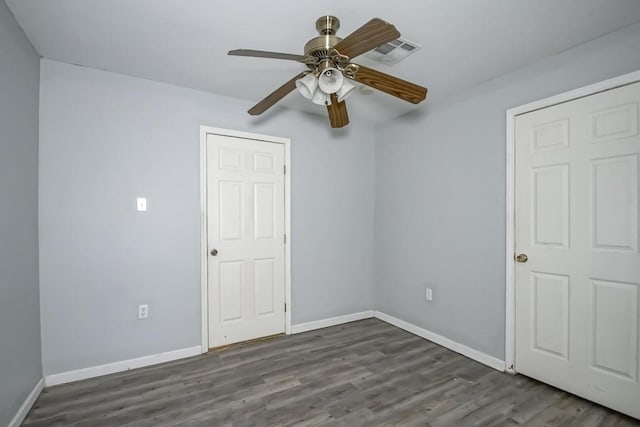 unfurnished bedroom featuring ceiling fan and dark hardwood / wood-style flooring